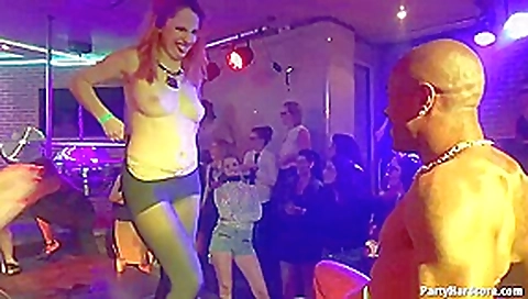 Kinky ladies are teasing a guy who is tied up on the stage, in the night club